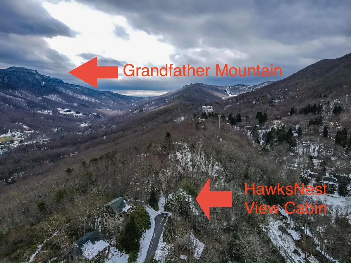 A sweeping view of Grandfather Mountain with HawksNest View Cabin nestled below, set in a snow-covered landscape. The majestic mountain backdrop showcases the property's proximity to major attractions and year-round adventure potential.